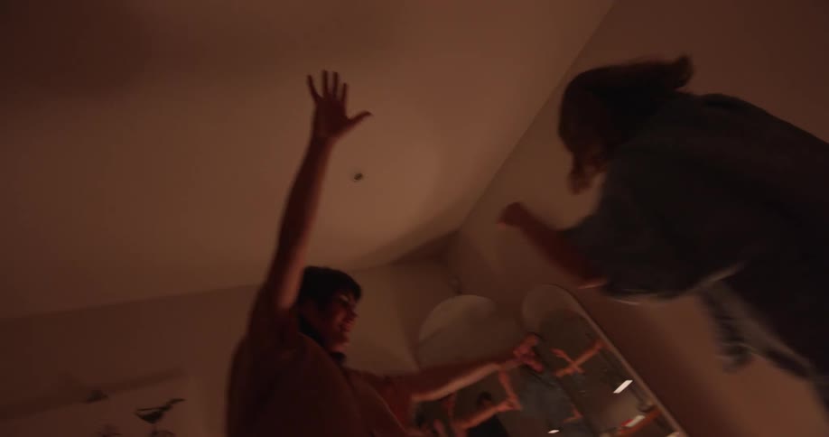 Two women dance and balance in room near three paneled mirror