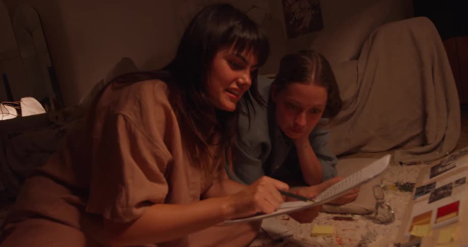 Two women work together on research project in dim room