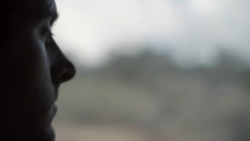 A man looks out the window while in a traveling vehicle