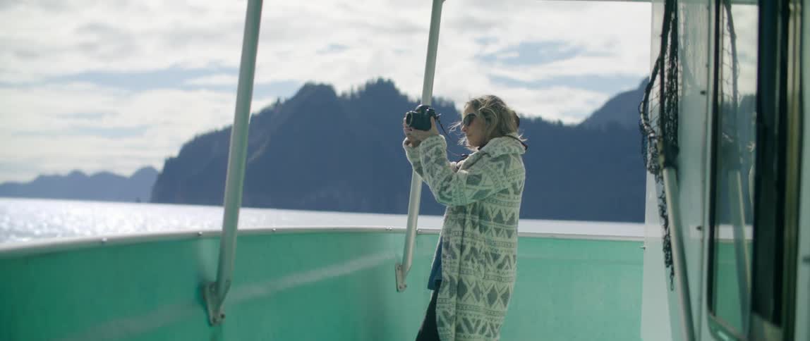 A woman is taking photographs from the boat