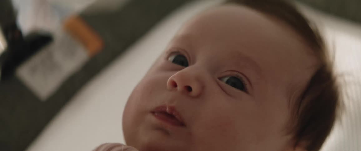 Baby in rocking cradle looks around