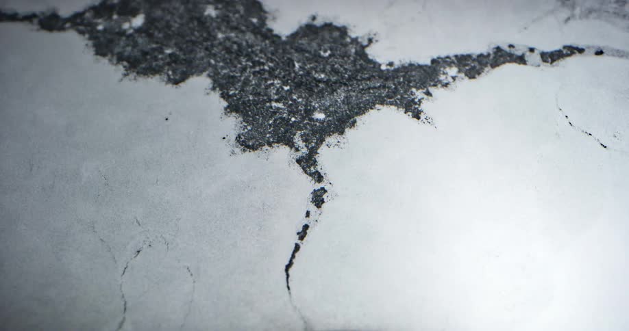 Surface ice cracks and breaks as water flows