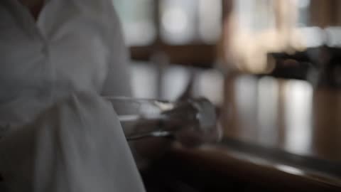A person at a bar cleaning a glass