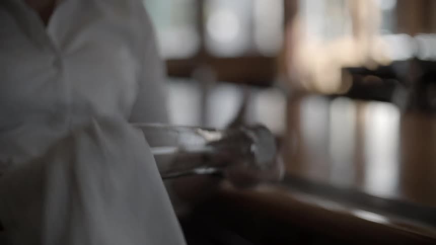 A person at a bar cleaning a glass