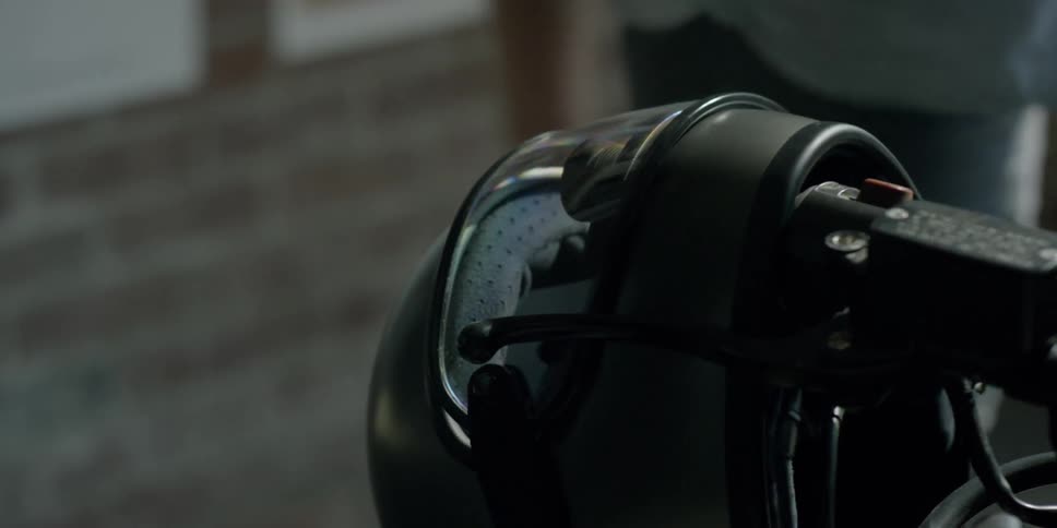 A person places their helmet on their handlebars