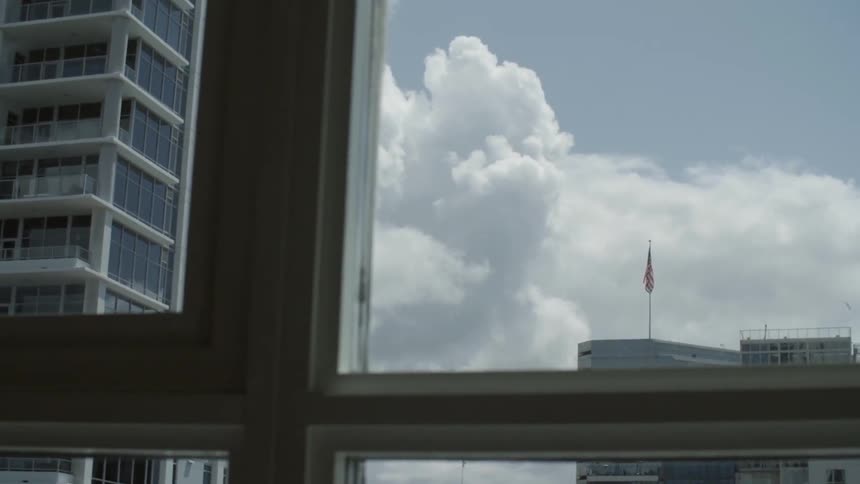 A flag is blowing on top of a building in the distance