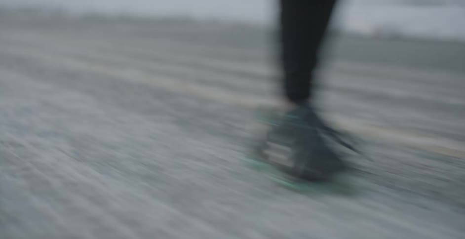 A persons feet who is running on pavement