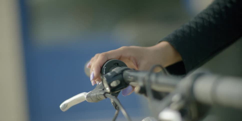 A woman's hand on the handlebar of their bicycle