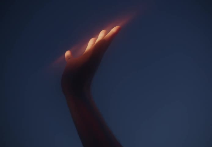 Lightshines on reaching hand blurring in around hand