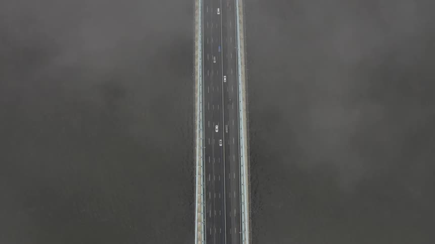 Cars are driving on a bridge over a body of water