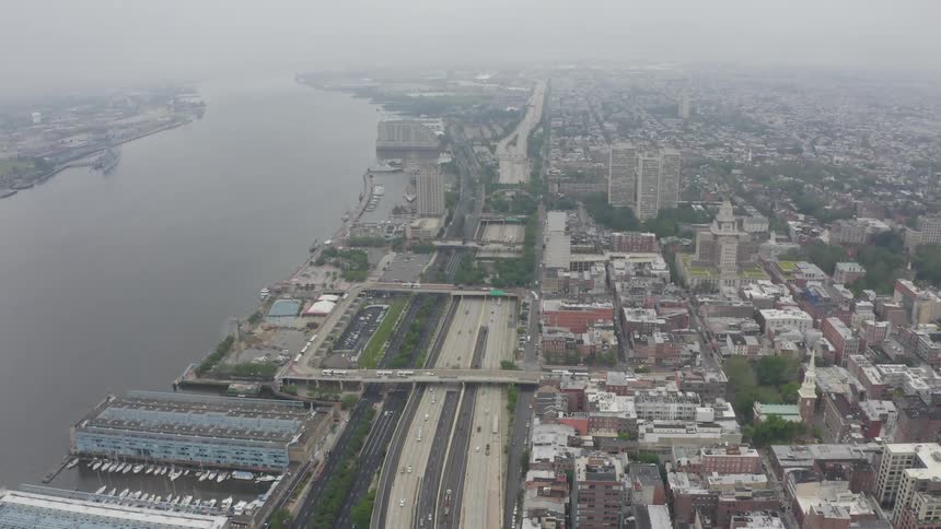 A freeway along a river in a metropolis on a foggy day