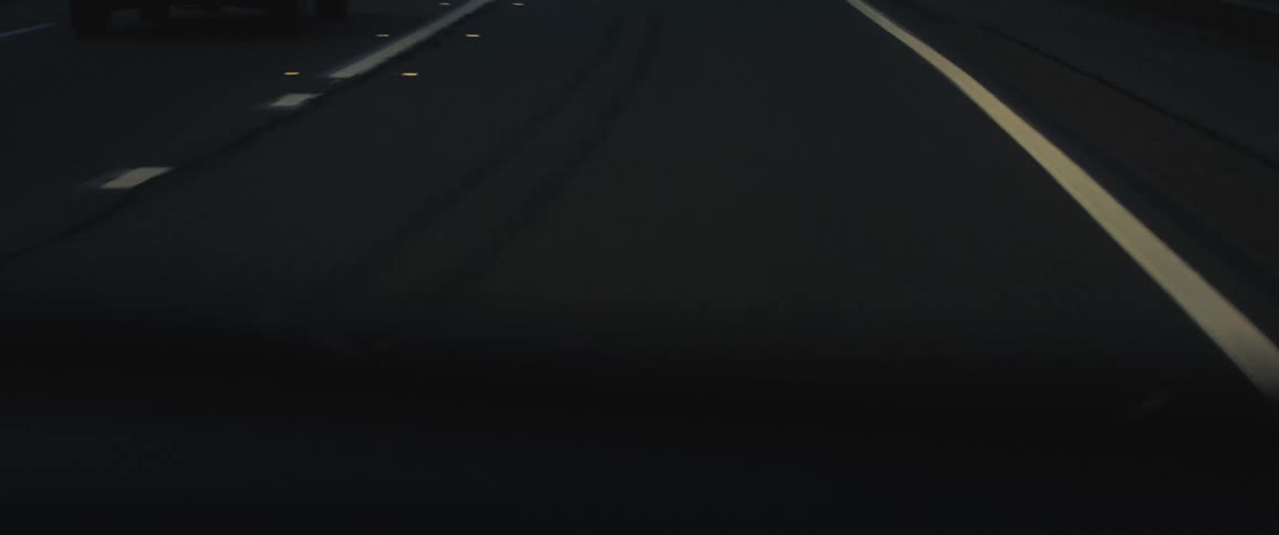 An extreme up close of a road with yellow lines and white dots