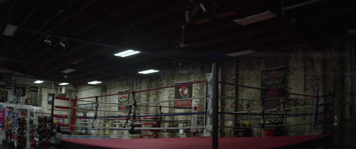 Lights turning on in an arena with a boxing ring