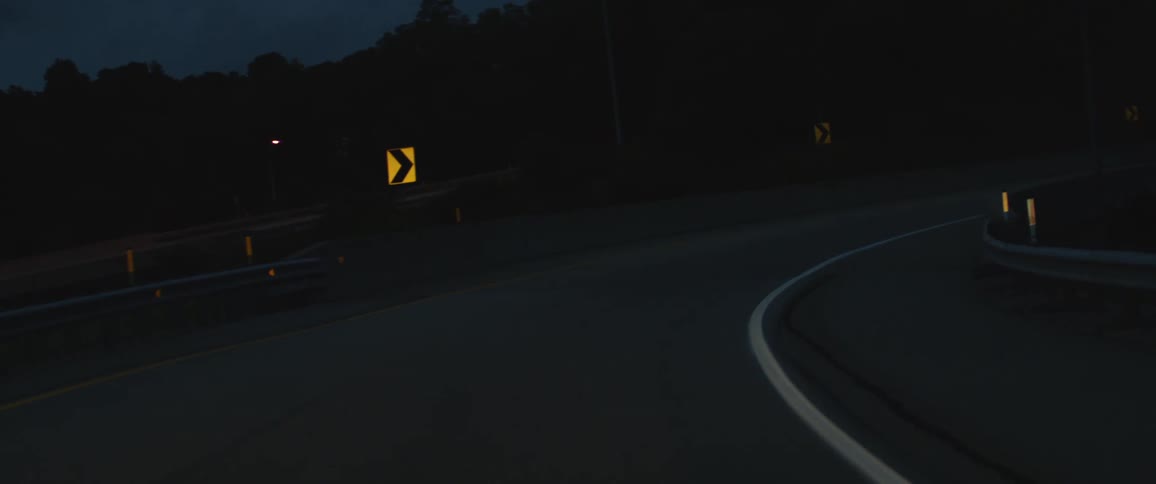 A view of an empty road is displayed during night time