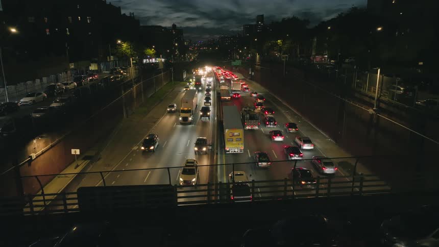 Cars trucks and bikes drive on highway seen from overpass at night