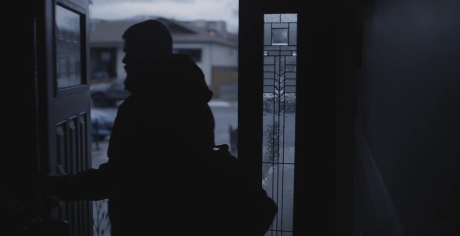 A man is leaving his house during the winter time