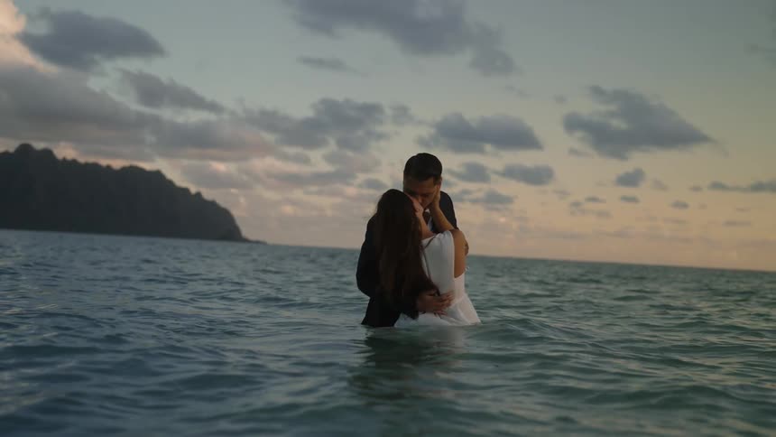 Man and woman are kissing in the ocean water