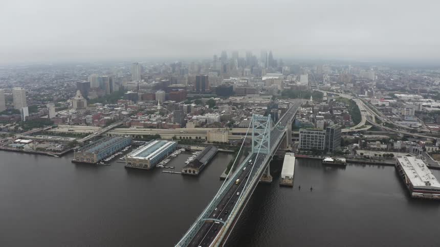 Aerial view of suspension bridge and skyline on a foggy day in the city