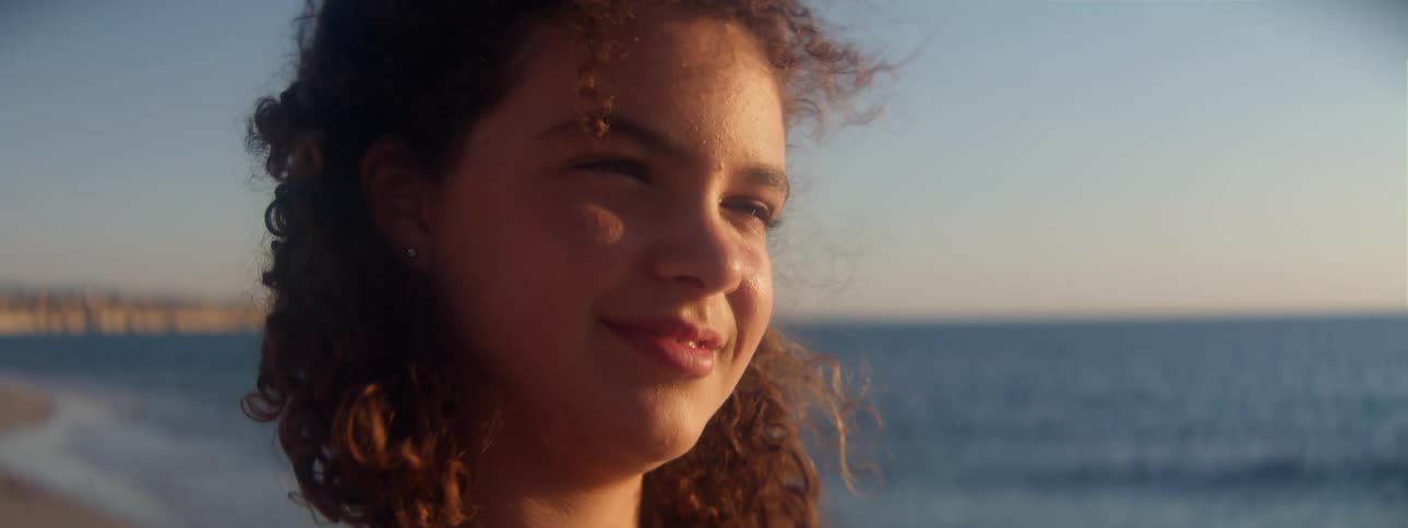 A girl is smiling on the beach