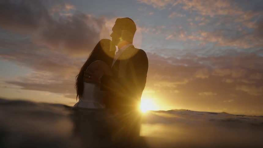 A married couple is standing in the water and be affectionate towards each other
