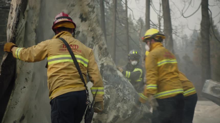There are fire fighters that are cleaning up after there was a fire