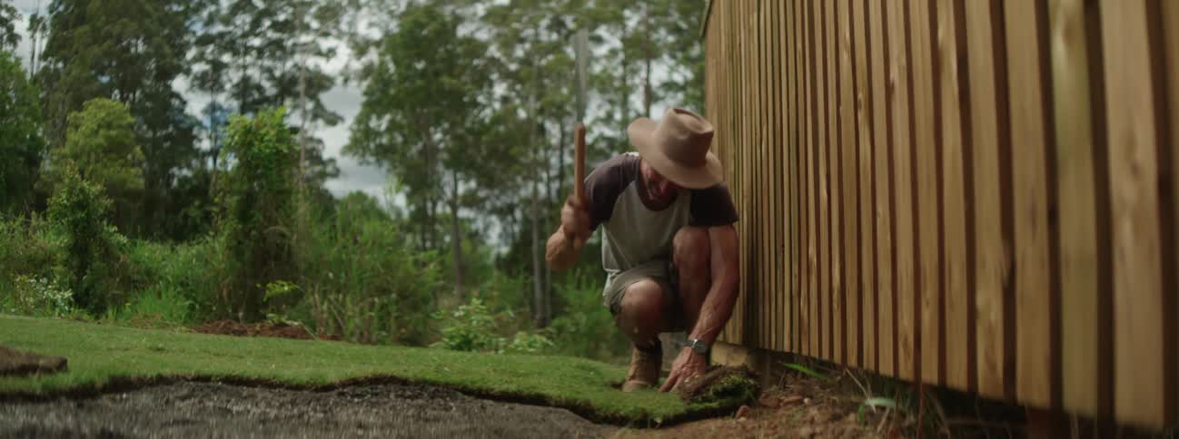 A man is cutting the grass in the yard