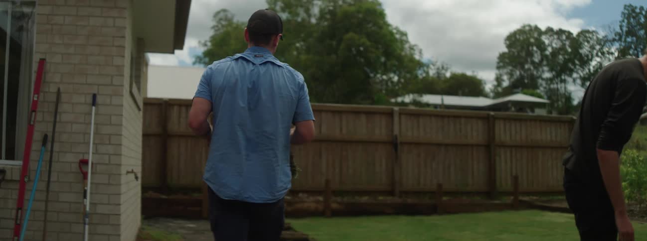 Two men are planting grass in the yard