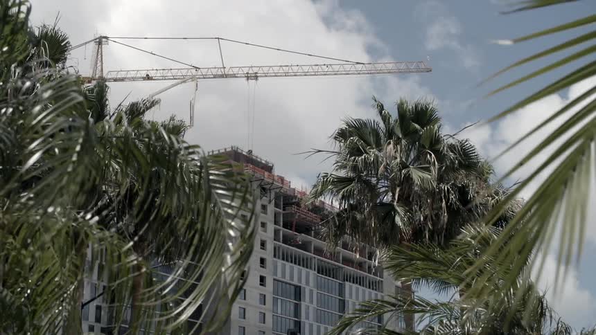 A large crane standing over a large building on a breezy day