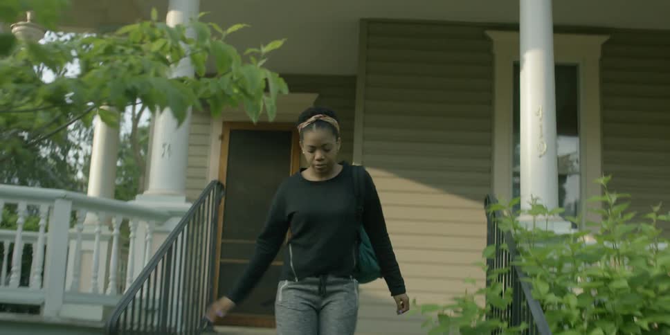 A woman rushes out of a house