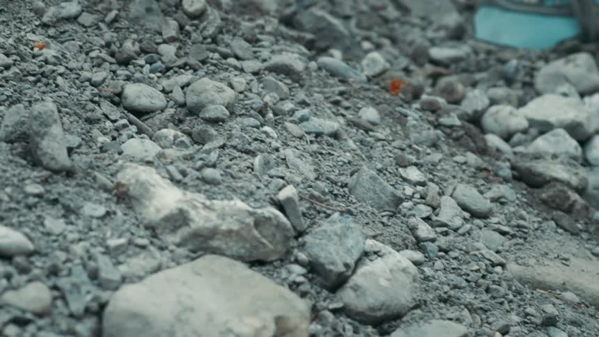 Small rocks roll down the side of a hill