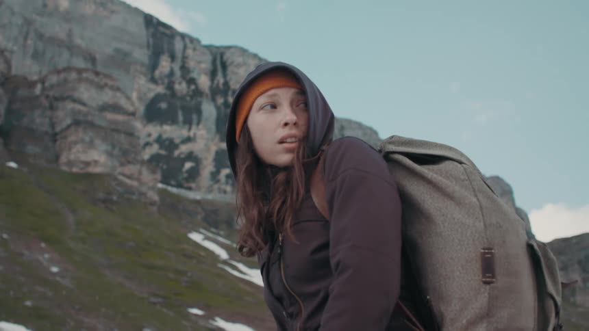 A woman turns near the mountain