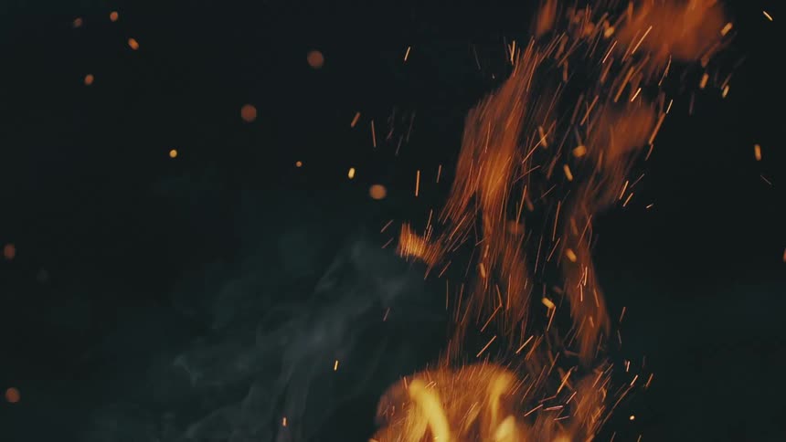 Flames and smoke rises into night sky