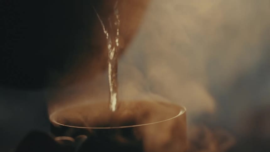 A person pours boiling water into a mug