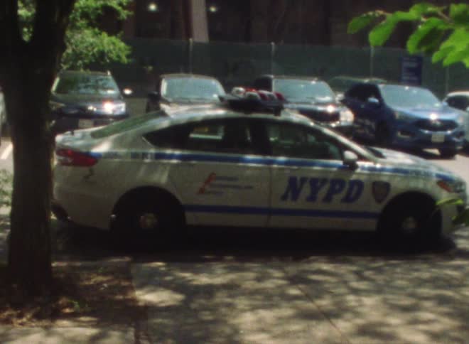 A police car is parallel parked in a parking lot