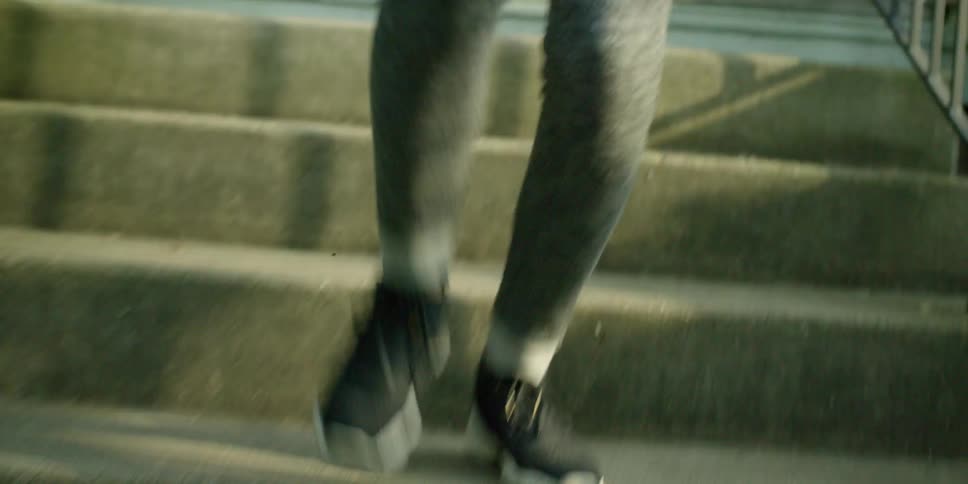 A woman walks down concrete steps outside