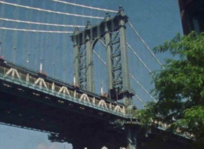 Sunlight shines on a suspension bridge under a clear blue sky