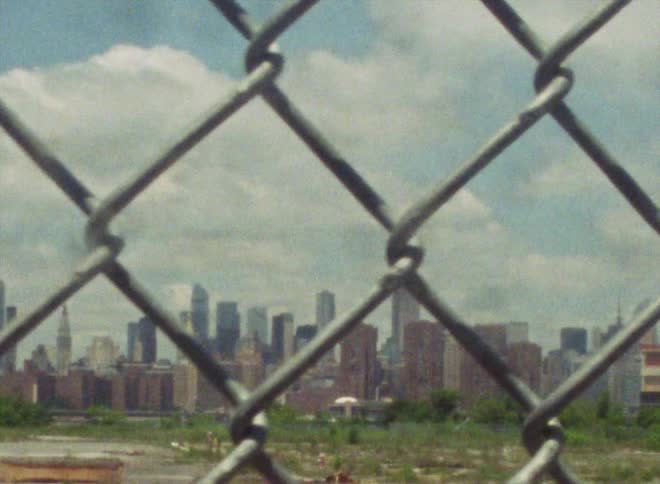 City skyline with skyscrapers and high rise buildings seen from behind the wire fences