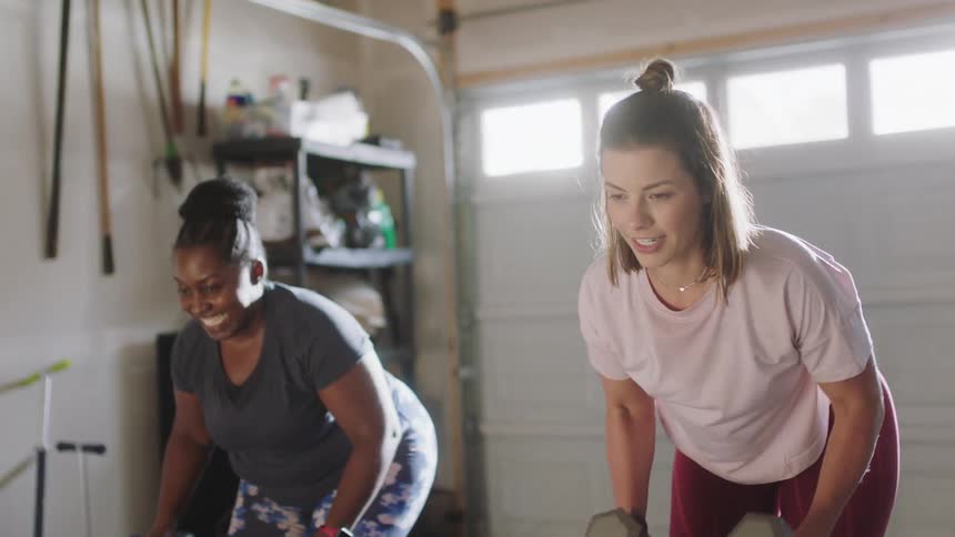 Two women are exercising indoors toghether