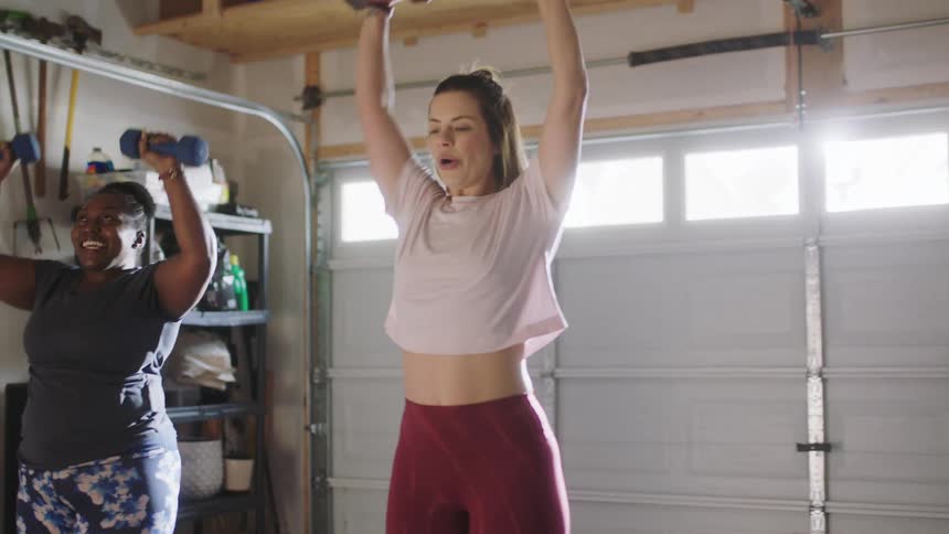 Two women are lifting weights together