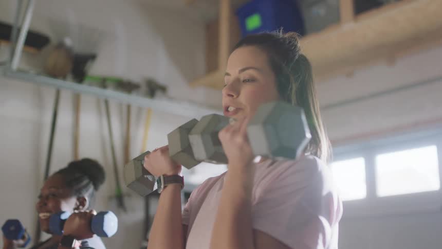 Two women are lifting weights together