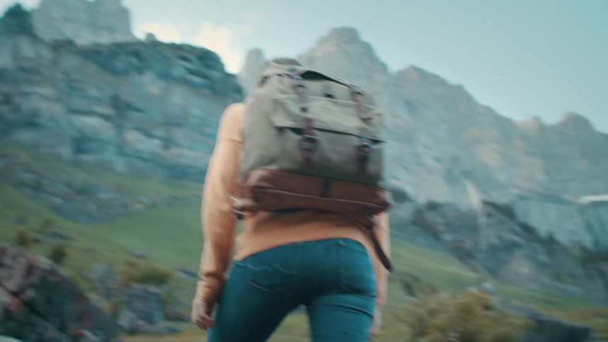 A woman is hiking towards the mountain