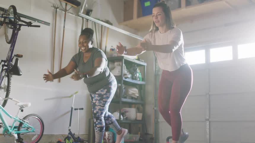 Women with leggings and t shirts work out in room