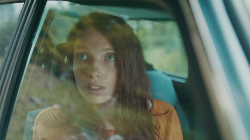 A female sightseeing out of a car window
