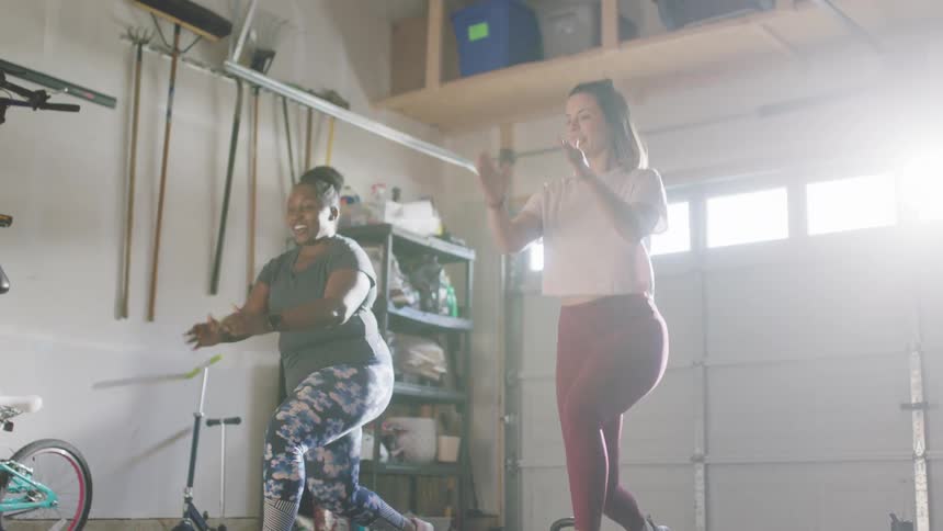 Two women with leggings and shirts exercises in room
