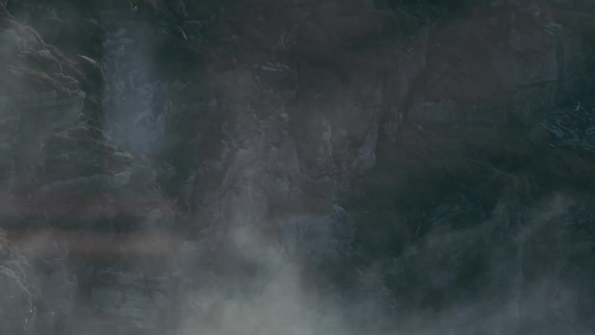 Thick vapor rises along ice dotted rock walls past piled branches