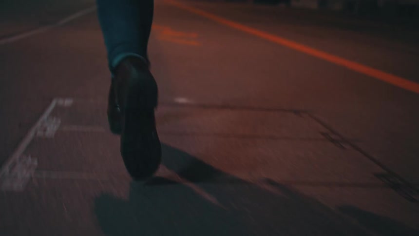 A view of a persons feet walking down the street