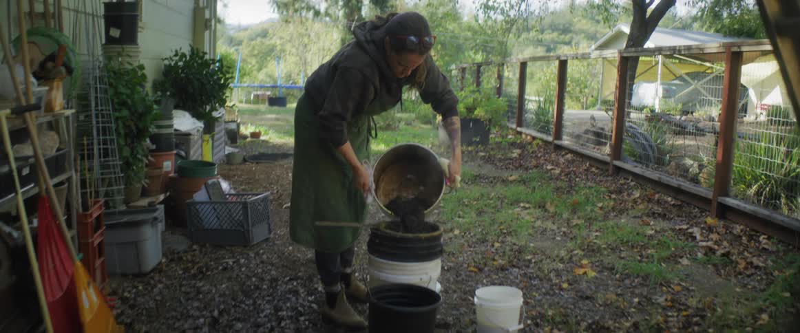 A woman pouring soil into a bucket