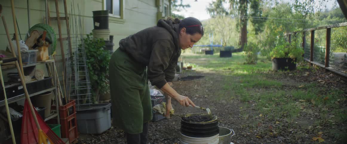 A woman is outdoors and is gardening during spring