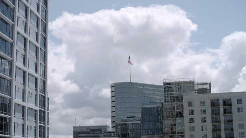 A flagpole on top of a glass building