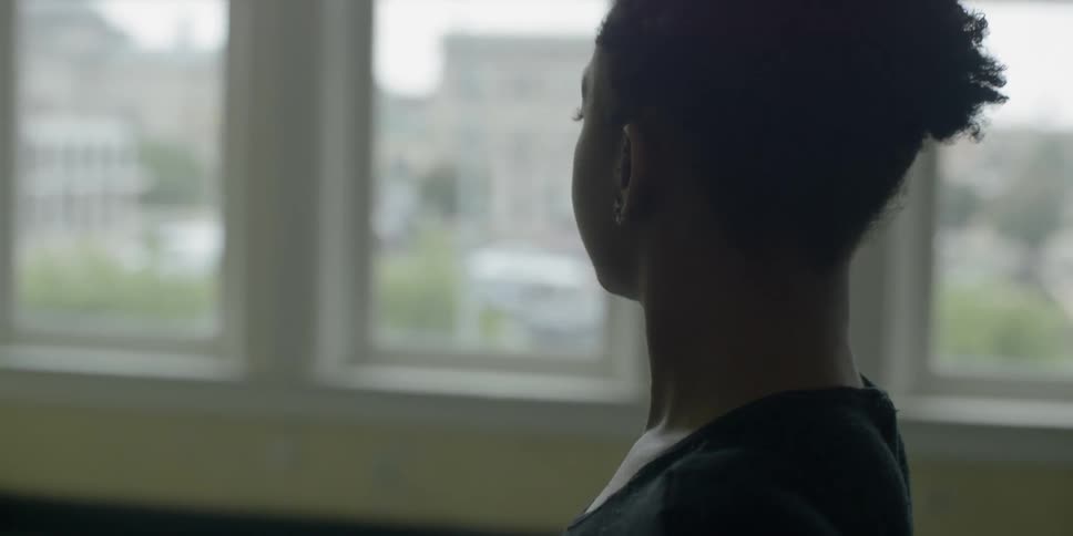A woman stretches in front of a window